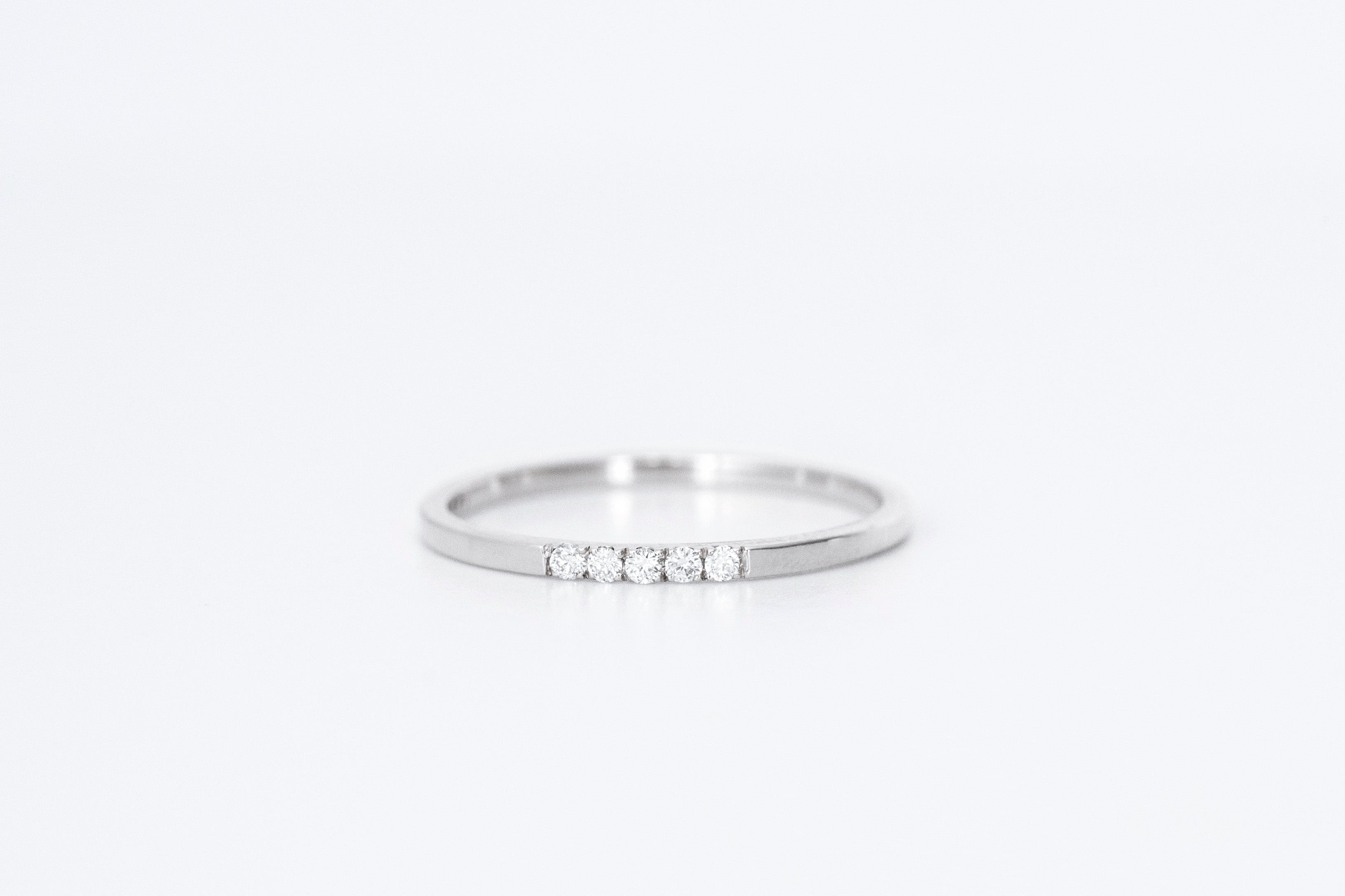 thin diamond wedding band with 5 small diamonds in white gold