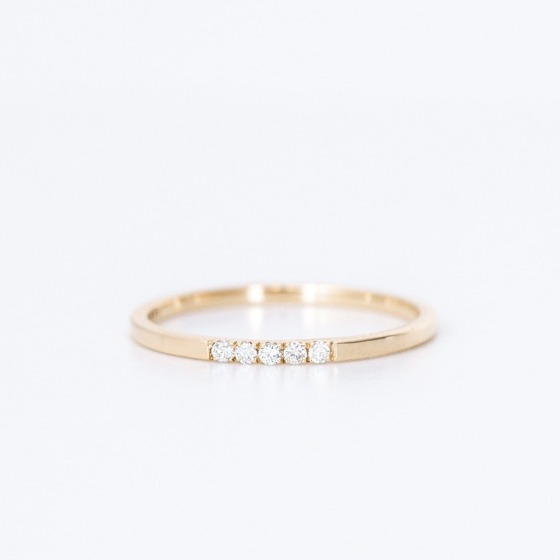 thin diamond wedding band with 5 small diamonds in yellow gold